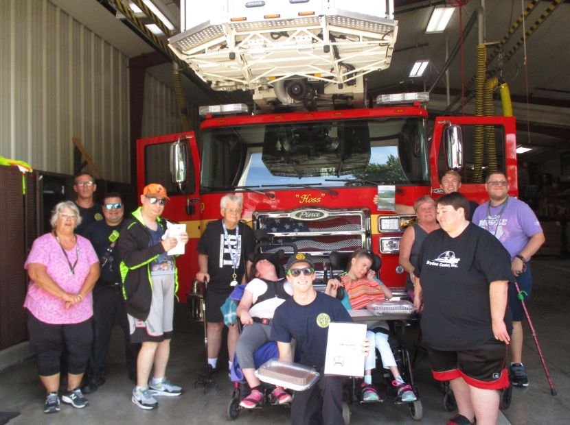 Group of people standing in front of a fire truck for Clinton, IA non-profit